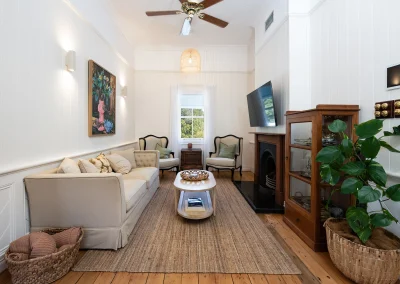 Small sitting room with a window, couch, coffee table, and two small chairs in North Maleny Country Cottage